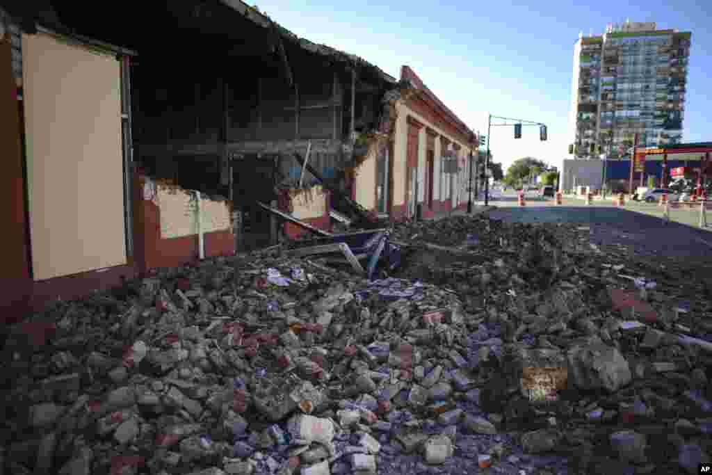 Los escombros de una pared derrumbada de un edificio cubren el suelo, en Ponce.