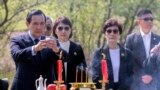 FILE - In this photo released by Xinhua News Agency, former Taiwan President Ma Ying-jeou, left, makes a libation as he paying respect to his grandfather's tomb in Xiangtan county, in central China's Hunan province, April 1, 2023. 