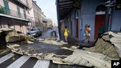 Bagian atap yang tertiup angin dari sebuah bangunan di French Quarter oleh Badai Ida menghalangi persimpangan, Senin, 30 Agustus 2021, di New Orleans. (Foto AP/Eric Gay)