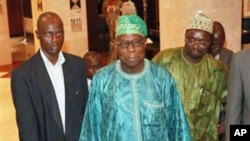 Former Nigerian President Olusegun Obasanjo, center, leaves his hotel for a meeting with incumbent Ivorian President Laurent Gbagbo in Abidjan, Ivory Coast, 08 Jan 2011