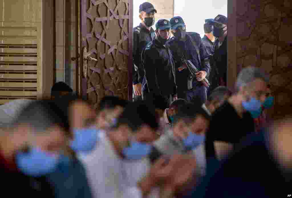 Palestinian Hamas police stand guard at the entrance of a mosque as worshipers attend the last Friday noon Prayer of the holy month of Ramadan, in Gaza City. 