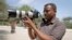 FILE - Somali journalist Mohamed Mohamud holds his camera in the Medina hospital compound in Mogadishu, Somalia, Jan. 18, 2013. Mohamud was killed on the job in 2013.