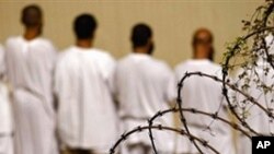 FILE - Detainees stand during an early morning Islamic prayer at the US military prison in Guantanamo Bay, Cuba, in 2009.