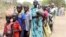 File - Residents displaced due to the fighting between government and rebel forces in the Upper Nile capital Malakal wait at a World Food Program outpost.