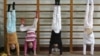 FILE - Members of the Nanjing children diving team practise standing on their hands during a training session at a sports college in Nanjing, Jiangsu province, Jan. 13, 2008. 