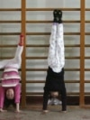 FILE - Members of the Nanjing children diving team practise standing on their hands during a training session at a sports college in Nanjing, Jiangsu province, Jan. 13, 2008. 