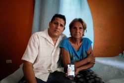 Alberto Betancourt y su madre Mayra Pérez posan con una foto de su hermana Daylin Betancourt, detenida por la policía durante una protesta, en La Habana, Cuba, el 19 de julio de 2021.