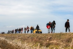 Migrants walk on the road near the Ipsala border gate in Edirne, at the Turkish-Greek border, March 3, 2020.