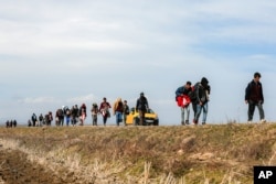 Migrants walk on the road near the Ipsala border gate in Edirne, at the Turkish-Greek border, March 3, 2020.