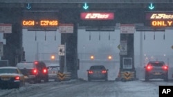 Des voitures attendent au péage d'un pont sous la neige dans le New Jersey, le 9 février 2017. 