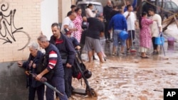 La gente camina por calles inundadas en Valencia, España, el 30 de octubre de 2024. 