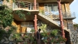 A man waters flowers outside a luxury house in the city of Kabul, Afghanistan, Sept. 29, 2024. (AP Photo/Siddiqullah Alizai)