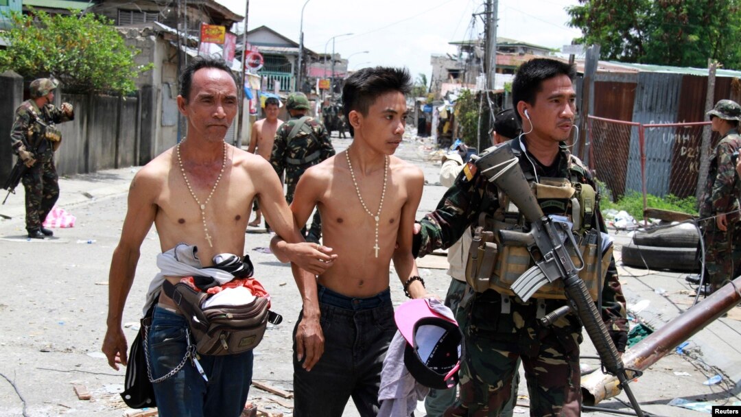 Tentara Pemerintah Filipina mendampingi warga yang disandera dan dijadikan 'tameng manusia' oleh para pemberontak muslim di kota Zamboanga, Filipina (17/9).