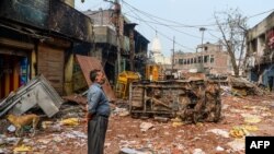 A resident looks at burnt-out and damaged residential premises and shops following clashes between people supporting and opposing a contentious amendment to India's citizenship law, in New Delhi, Feb. 26, 2020.