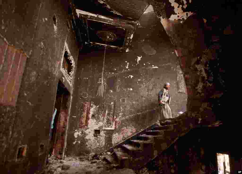 June 16: A tribesman loyal to Yemeni opposition tribal chief Sheikh Sadiq al-Ahmar walks inside the destroyed headquarters of al-Ahmar in Sanaa. (Reuters/Suhaib Salem)
