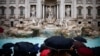 Orang-orang berkumpul pada hari Air Mancur Trevi (Fontana di Trevi) dibuka kembali untuk umum setelah pekerjaan pemeliharaan, di Roma, Italia. (Reuters)&nbsp;