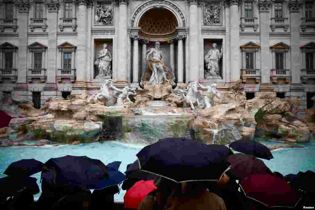 People gather on the day the Trevi Fountain reopens to the public after maintenance work, in Rome, Italy.