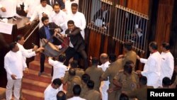 Parliament member Johnston Fernando who is backing newly appointed Prime Minister Mahinda Rajapaksa throws a chair at police who are there to protect parliament speaker Karu Jayasuriya (not pictured) during a parliament session in Colombo, Sri Lanka, Nov. 16, 2018.