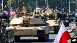 Tanques Abrams estadounidenses comprados por Polonia desfilan en Varsovia, el 15 de agosto de 2023.