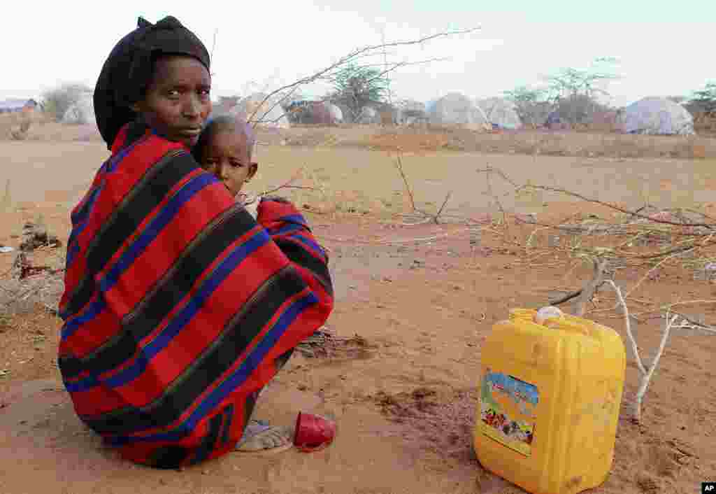 A newly arrived refugee woman and her child from Baidoa in Somalia sit in the open as they camp with their belongings outside Ifo refugee camp in Dadaab, near the Kenya-Somalia border, July 30, 2011. (Reuters)
