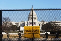 National Guardsmen are seen Jan. 13, 2021, at a fence that was erected to reinforce security at the Capitol in Washington.