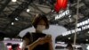 A visitor checks a mobile phone near the Huawei logo during the Mobile World Congress in Shanghai, China June 28, 2023.