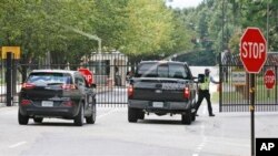 Guardias de seguridad abren las puertas en el Fuerte Lee, en el sur de Virginia, donde se reportó un tiroteo.