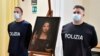 Policías italianos posa junto a una copia del "Salvator Mundi" (Salvador del mundo) de Leonardo da Vinci, en Nápoles, Italia, el miércoles 20 de enero de 2021.
