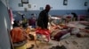 FILE - A migrant carries his belongings at a detention center for mainly African migrants, that was hit by an airstrike in the Tajoura suburb of Tripoli, Libya, July 3, 2019.