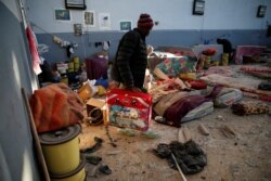 A migrant carries his belongings at a detention center for mainly African migrants, that was hit by an airstrike in the Tajoura suburb of Tripoli, Libya, July 3, 2019.