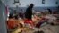 FILE - A migrant carries his belongings at a detention center for mainly African migrants, that was hit by an airstrike in the Tajoura suburb of Tripoli, Libya, July 3, 2019.