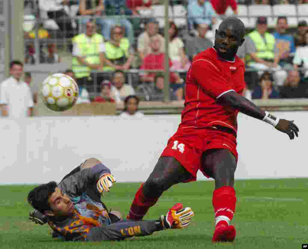 L&#39;ancien footballeur libérien George Weah , à droite, marque un but au cours du match de son jubilé joué à Marseille, au Sud de la France, samedi 11 juin 2005. Weah a annoncé sa candidat aux prochaines élections pour le Sénat après au Liberia.