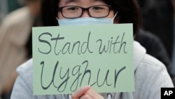 A man holds a sign during a rally to show support for Uighurs and their fight for human rights in Hong Kong, Dec. 22, 2019.