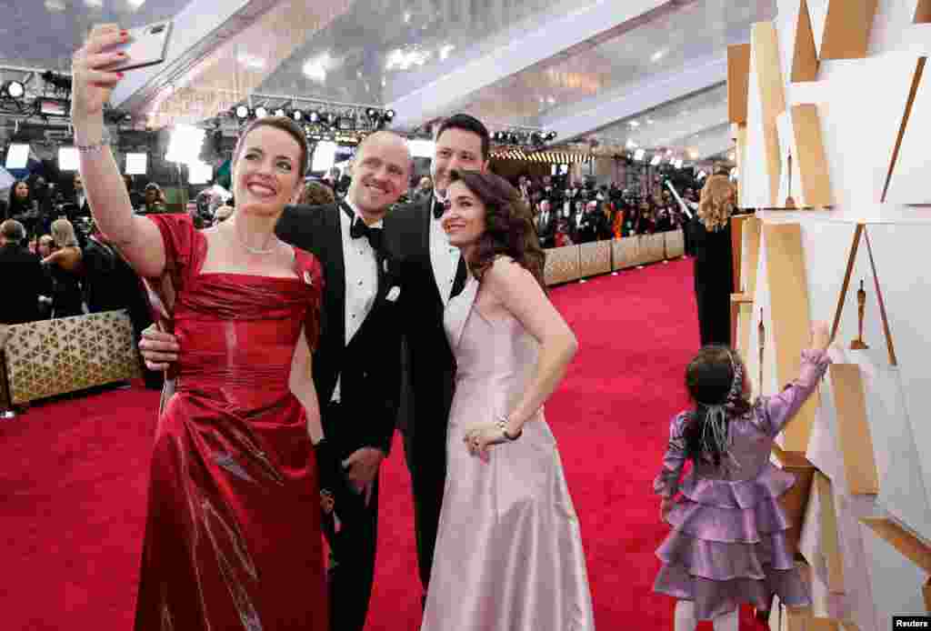 Waad al-Kateab, Hamza Al-Kateab, Olivia Scarlett-Watts and Edward Watts pose for a selfie on the red carpet during the Oscars arrivals at the 92nd Academy Awards in Hollywood