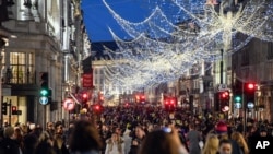 Para pengunjung mengenakan masker wajah di Regent Street, menjelang pengetatan baru terkait virus corona, di London, Sabtu, 19 Desember 2020. (Foto: Reuters)