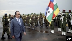 FILE: Then-French President Francois Hollande reviews troops as he arrives in Bangui Friday, May 13, 2016. 