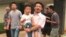 This image taken from video shows Chinese labor activists Hua Haifeng, center, carrying his son Bobo, and Li Zhao, second from left, leave a police station after being released in Ganzhou in southern China's Jiangxi Province, June 28, 2017.