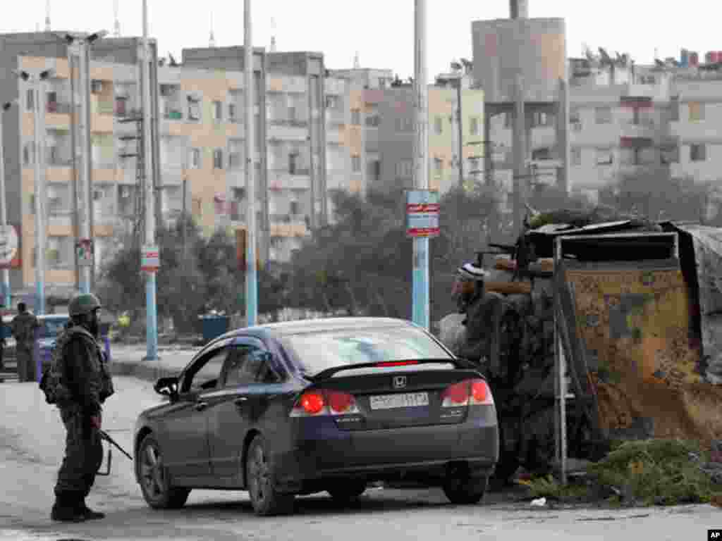 Syrian soldiers are seen at a checkpoint outside Damascus in Harasta, January 26, 2012. (Reuters)
