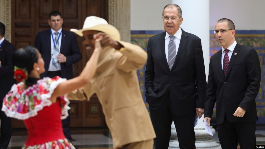 El canciller ruso, Serguei Lavrov, y su contraparte venezolano, Jorge Arreaza, observan a una pareja bailando una danza folklórica en Caracas, Venezuela, el viernes, 7 de febrero de 2020.
