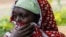 A woman reacts as members of the Kenya Defense Forces search for the bodies of missing people after flash floods wiped out several homes following heavy rains in Kamuchiri village of Mai Mahiu, Kenya, on May 1, 2024.