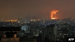 An explosion lights the sky following an Israeli airstrike on Beit Lahia in the northern Gaza Strip, May 14, 2021. 