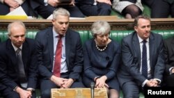 FILE - Britain's Prime Minister Theresa May reacts during the debate on extending Brexit negotiating period in Parliament in London, Britain, March 14, 2019. 