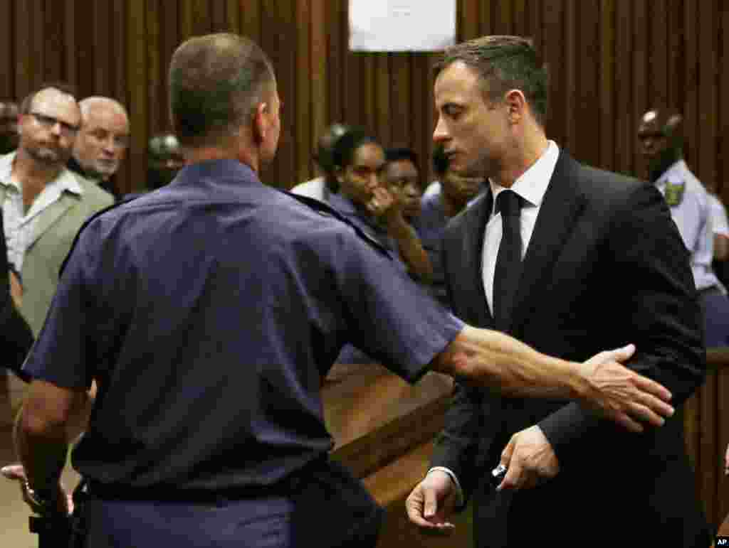 Oscar Pistorius, à droite, a été emmené en prison à la sortie de l&#39;audience. mardi le 21 octobre 2014. 