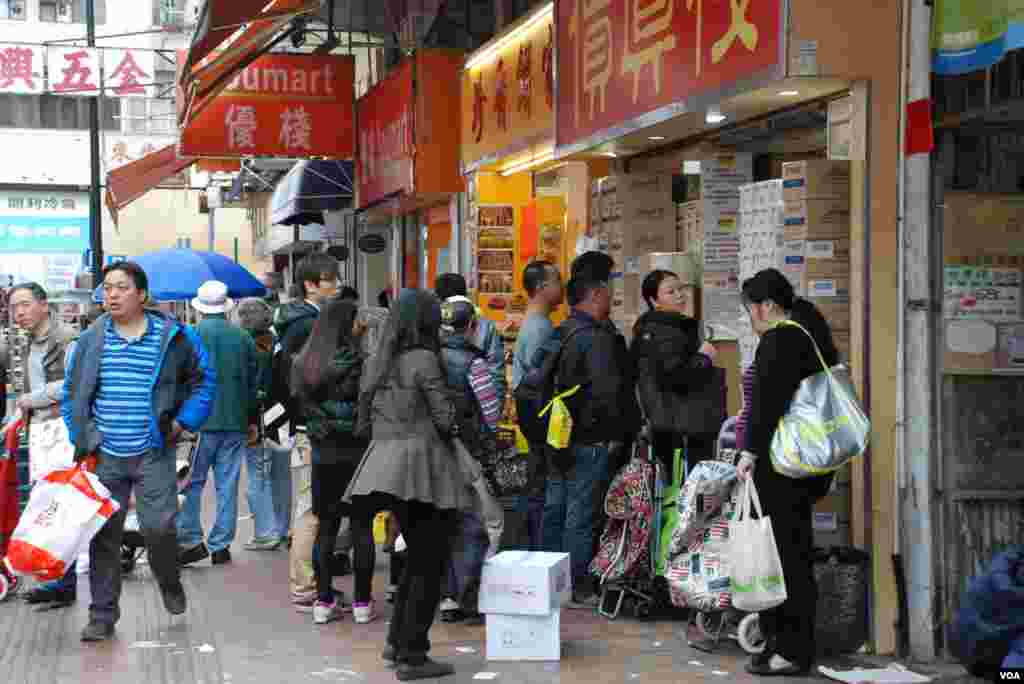 大批水貨客及大陸自由行旅客在上水石湖墟批發店排隊買年貨，有旅客表示要輪候20分鐘