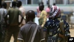 Armed men walk past on April 17, 2011 as resentment towards the capital Khartoum runs high in the restive town of Abyei