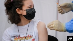 A girl gets a Pfizer BioNTech COVID-19 vaccine in Bucharest, Romania, June 2, 2021