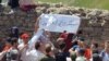 In this undated photo published by the U.S.-based Center for Human Rights in Iran, Iranian Azerbaijanis stage an annual July protest against discrimination targeting their community at Babak Fort in East Azerbaijan province. The slogan on the white banner calls for the release of a detained Azeri rights activist, Siamak Mirzaei.