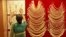 A saleswoman arranges a gold necklace inside a jewellery showroom in the southern Indian city of Kochi, April 16, 2013. 