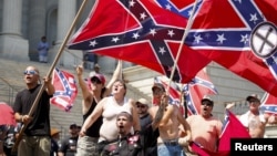 Para anggota Ku Klux Klan berteriak sambil mengibarkan bendera Konfederasi dalam demonstrasi di gedung DPRD South Carolina di Columbia, 2015. (Foto: Dok)