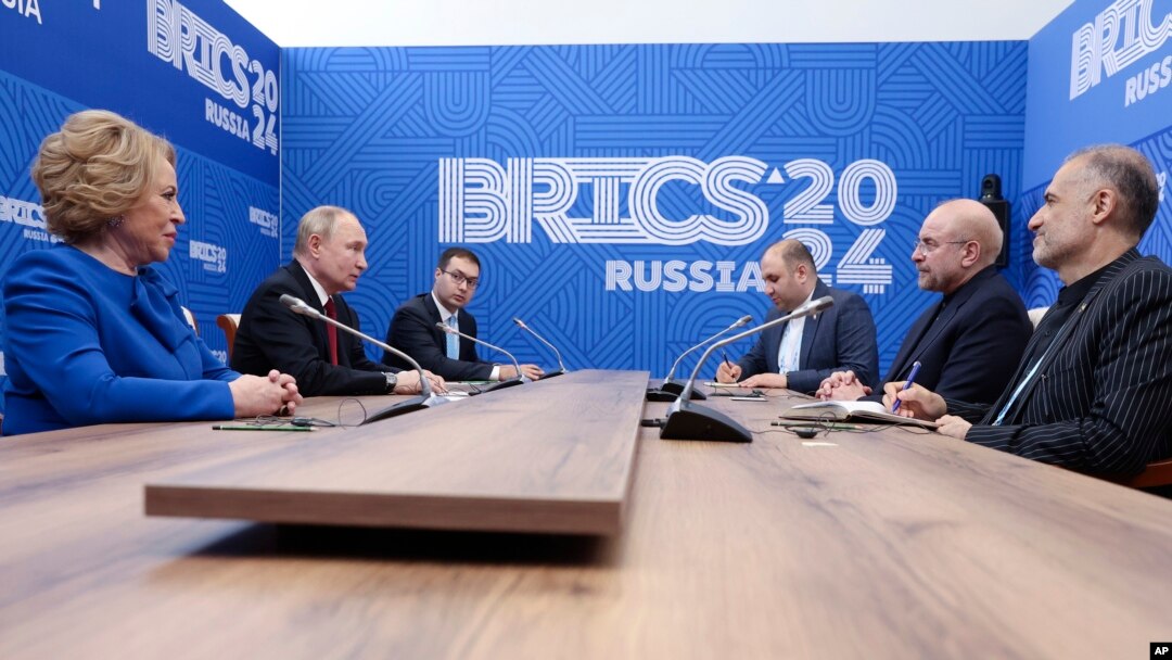 Presiden Rusia Vladimir Putin (kiri) berbicara dengan Ketua Parlemen Iran Mohammad Bagher Ghalibaf, ke-2 dari kanan, selama pertemuan mereka di sela-sela Forum Parlemen BRICS di St. Petersburg, Rusia, Kamis, 11 Juli 2024.